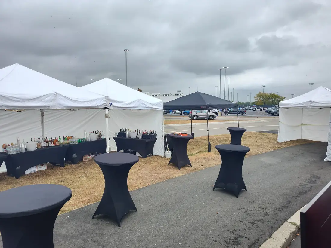 Clean white tents and high-top tables set up for an event